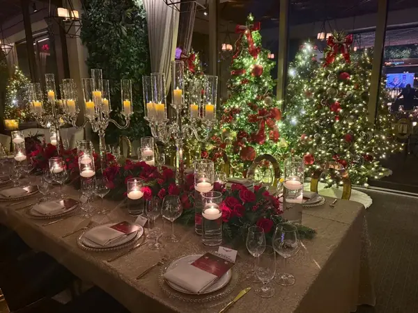 Candlelit holiday dinner among decorated Christmas trees